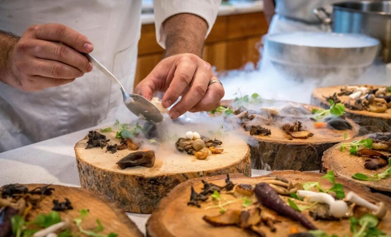 chef preparing vegetable dish on tree slab
