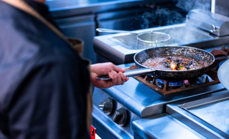 a man in an apron cooking food in a kitchen